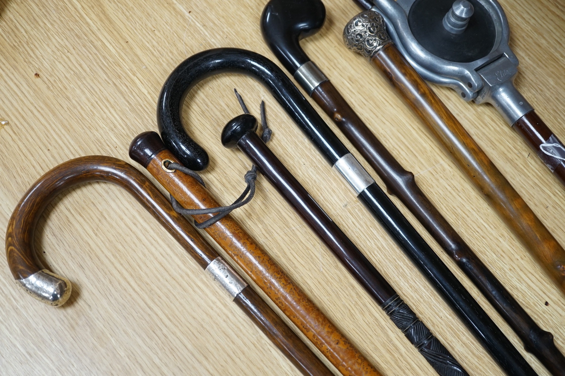 Four silver mounted walking canes, a malacca cane, a carved hardwood cane and a shooting stick (7)